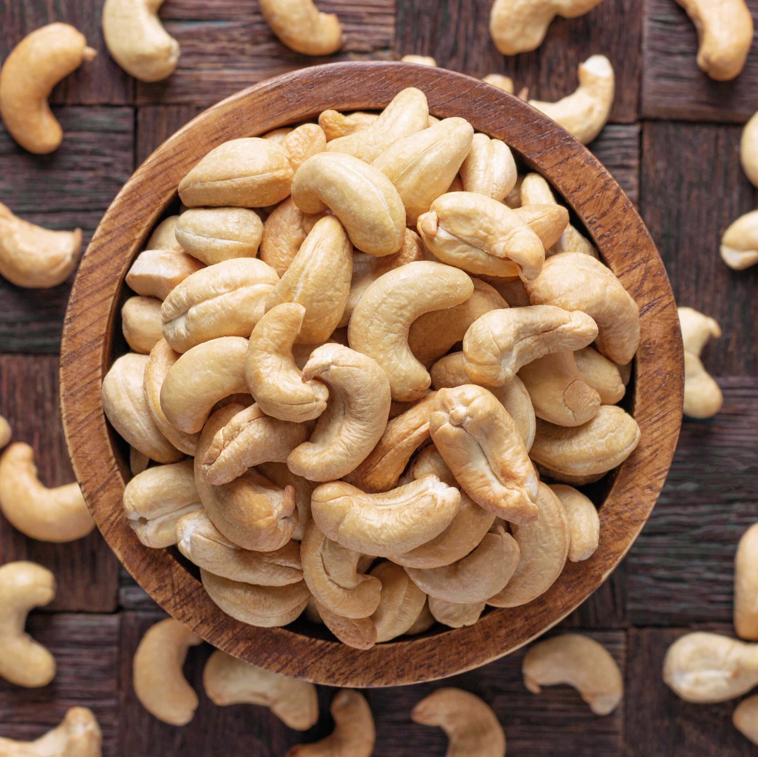 cashew nuts peeled roasted in wooden bowl, top view.